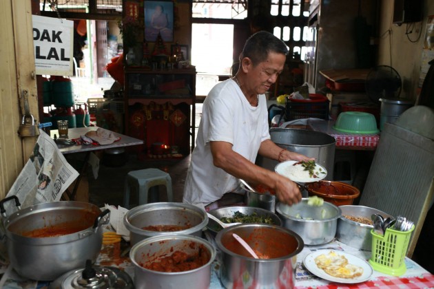 The owner of the stall preparing a meal.