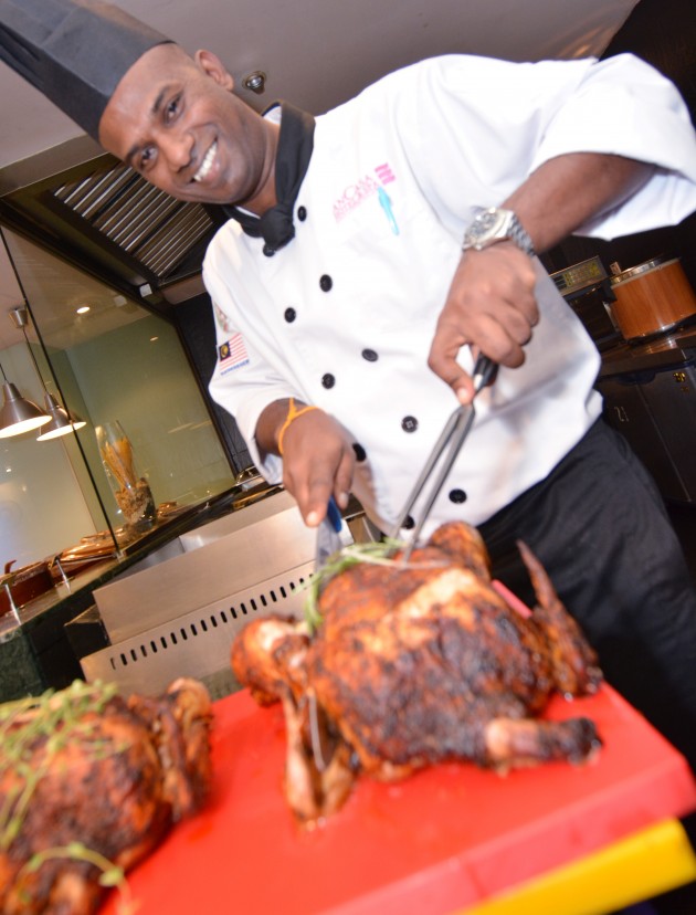 Ancasa Hotel and Spa Kuala Lumpur's executive sous chef Ricky Narayanan carving a grilled chicken.