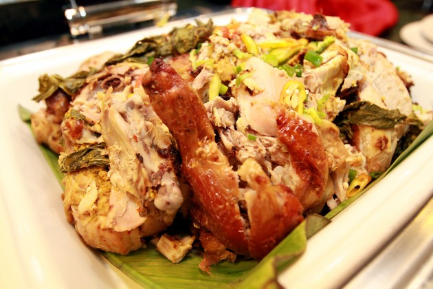 Ayam Bertutu is baked chicken stuffed with curry paste and cassava leaves.