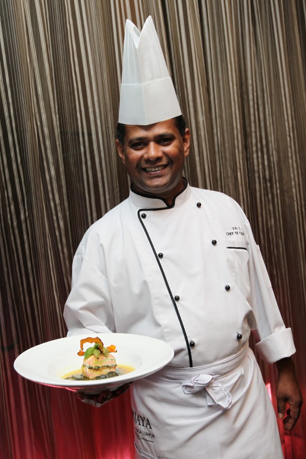 Chef Valmurugan with a plate of Steamed Salmon Napoleon.