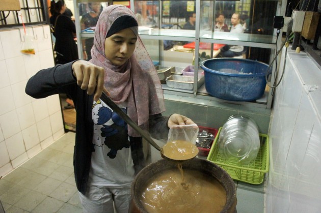 Stall proprietor Noor Jannah Rahim ladling soup for a takeaway order.