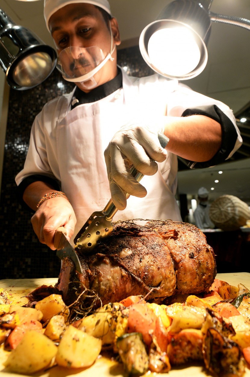 Expert hands: A chef carving succulent roast beef at the carvery station.