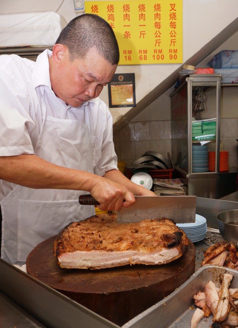 Hard at work: Wong begins serving his famous roast pork at 12.30pm and does not stop chopping up meat until 3pm.