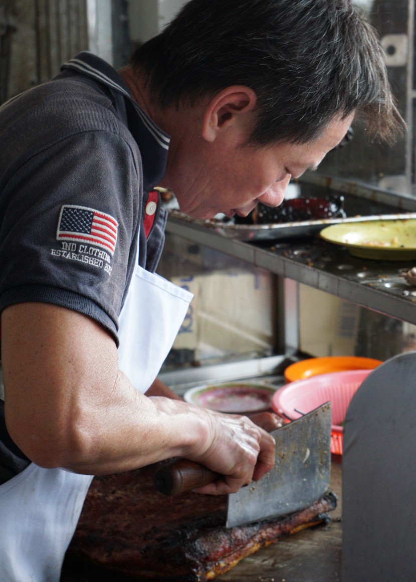 Making the cut: The owner of the chicken rice stall in Hong Seng Restaurant carefully cutting the siew yoke for customers.