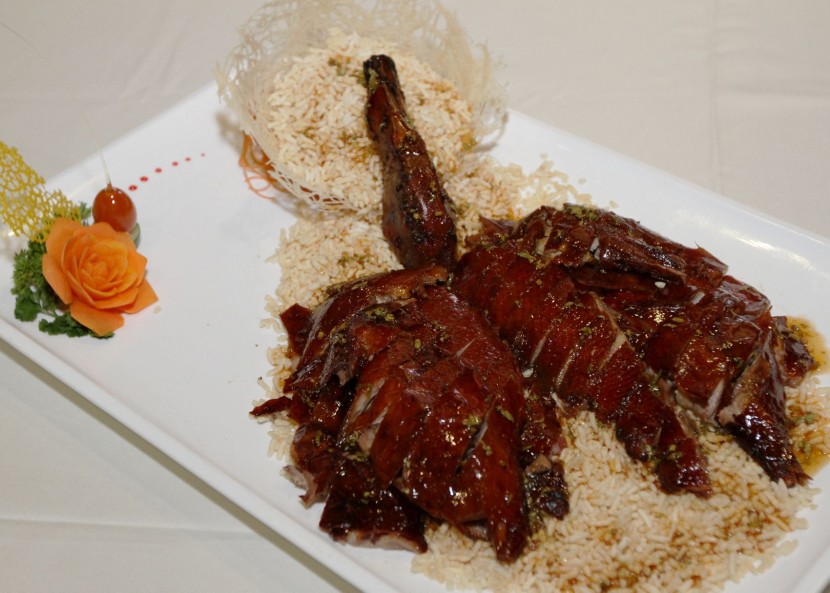 Roasted duck served with plum sauce and crispy rice.