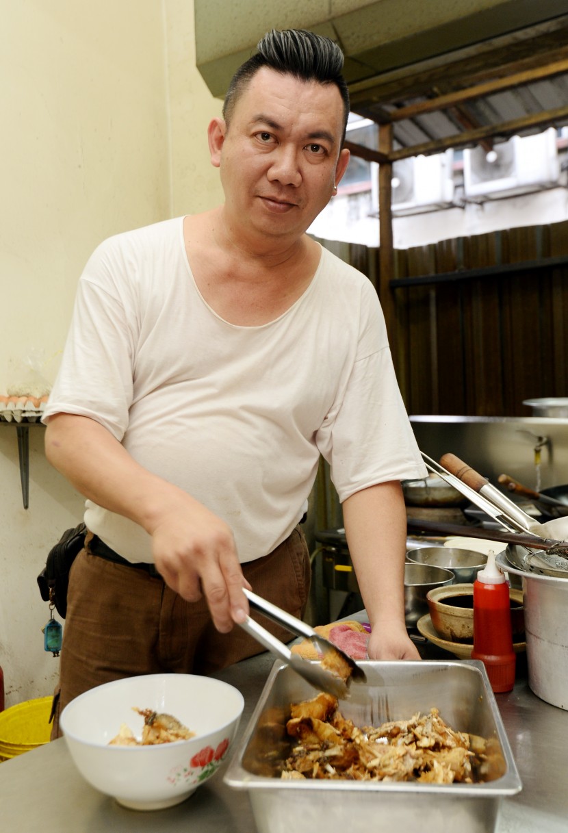 Satisfying meal: Leong preparing the fried fish head before putting it in the soup.