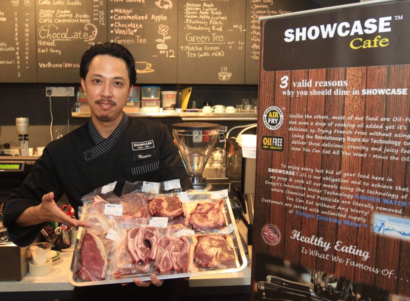 Showcase Cafe owner Nicolas Tan showing the tray of meat cuts that customers can choose from when ordering a steak of lamb rack.