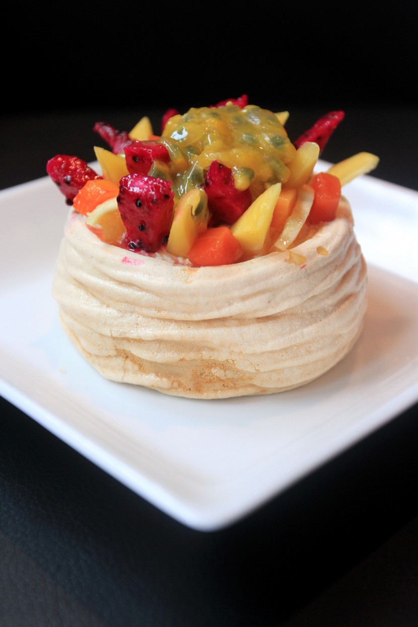 The pavlova is topped with a selection of fruits.