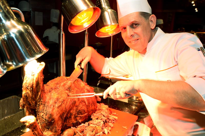 Executive chef Helmut Lamberger cuts into succulent grilled whole lamb. The dish will be available everyday during at the Ramadan buffet.
