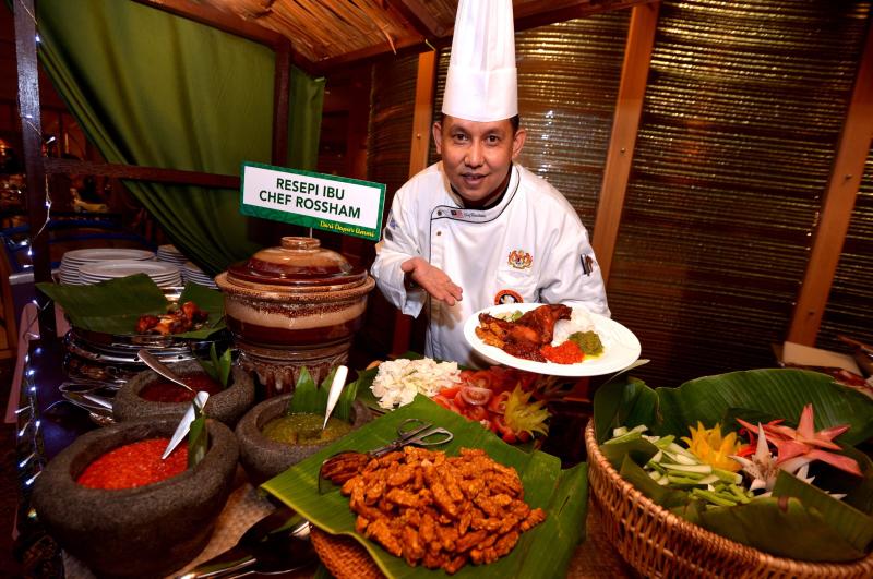 Sunway Putra hotel Coffeehouse executive chef Rossham Rosli posing with a plate of Nasi Ayam Goreng Kampung at his stall.