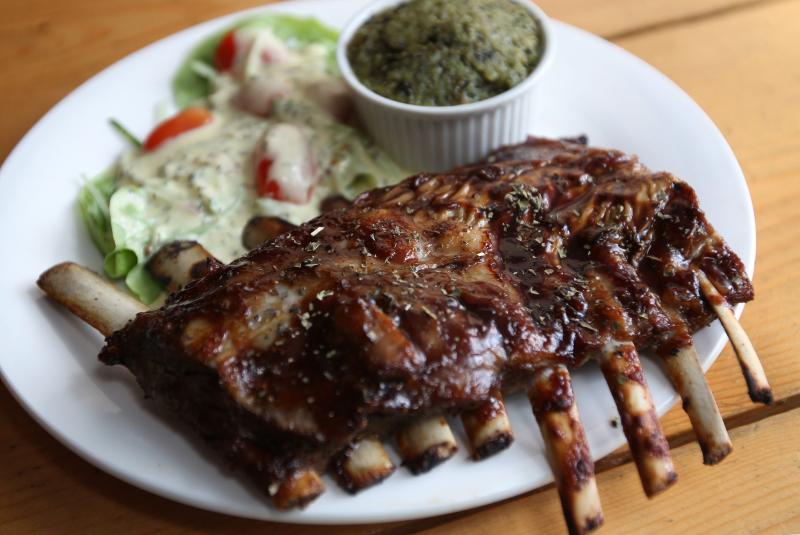 The lamb ribs is served with pesto mashed potatoes and a side of salad.