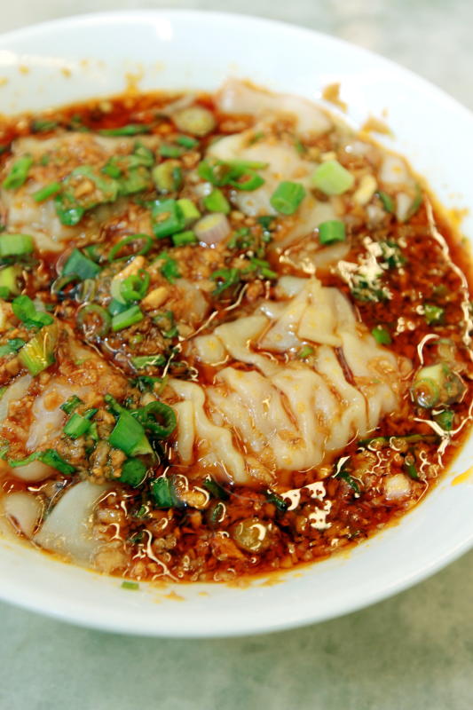 The Sichuan-Style Dumpling is served in a gravy of vinegar and chilli oil, topped with garlic, coriander and spring onion.